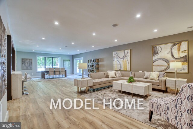 living room with recessed lighting, baseboards, visible vents, and wood finished floors