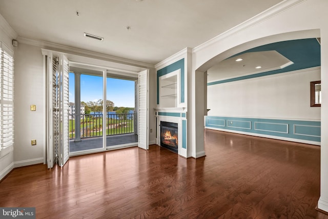 unfurnished living room with crown molding, a tile fireplace, wood finished floors, and visible vents