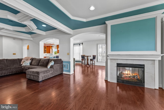 living room featuring crown molding, arched walkways, a fireplace, and wood finished floors