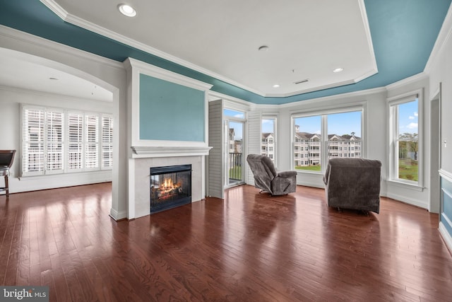 living area featuring ornamental molding, wood finished floors, and a fireplace