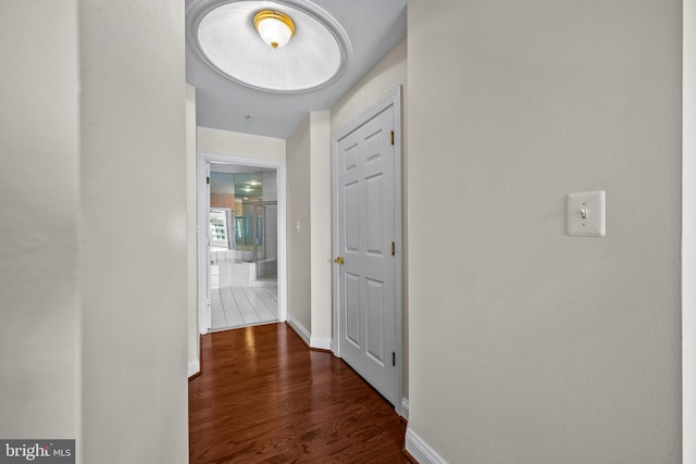 hall with baseboards and wood finished floors