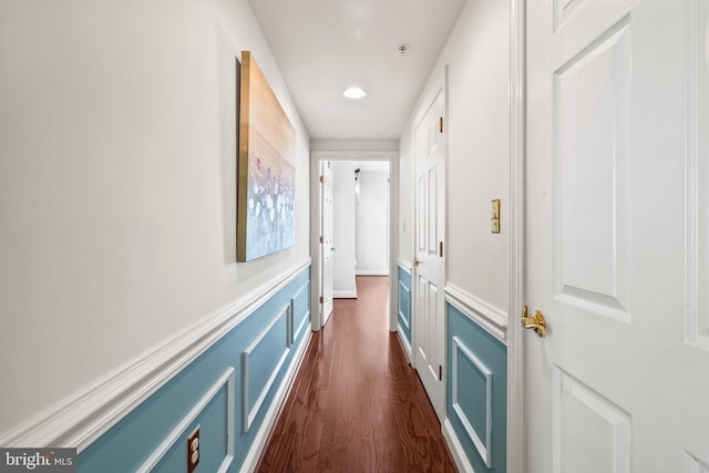 hallway with recessed lighting, dark wood finished floors, and a wainscoted wall