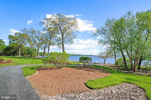 surrounding community featuring a lawn and a water view