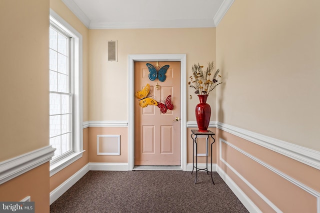 interior space featuring baseboards, visible vents, ornamental molding, and dark carpet