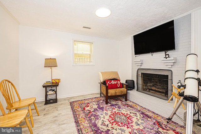 11039 Timberview Dr, Manassas, VA 20111 - living area with a brick fireplace, a textured ceiling, wood finished floors, and baseboards