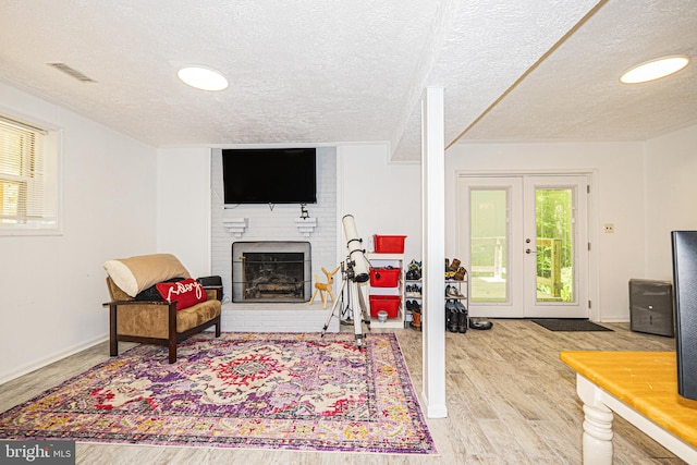 11039 Timberview Dr, Manassas, VA 20111 - living area with wood finished floors, a textured ceiling, french doors, a fireplace, and baseboards
