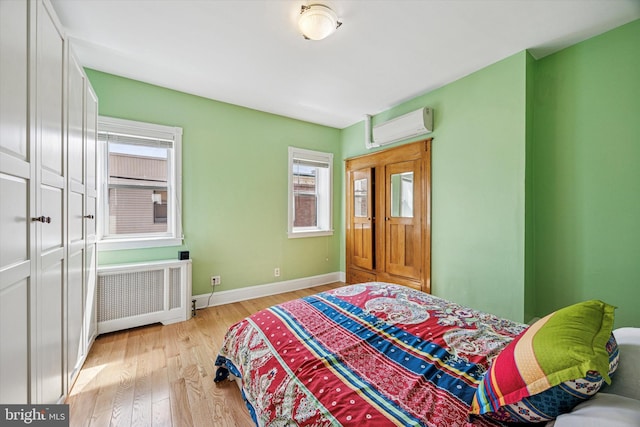 2410 S Camac St, Philadelphia, PA 19148 - bedroom featuring baseboards, light wood-type flooring, radiator, and a wall mounted air conditioner