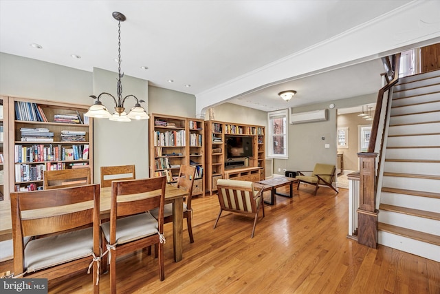 2410 S Camac St, Philadelphia, PA 19148 - dining space featuring light wood-style flooring, a wall mounted AC, a notable chandelier, and stairway