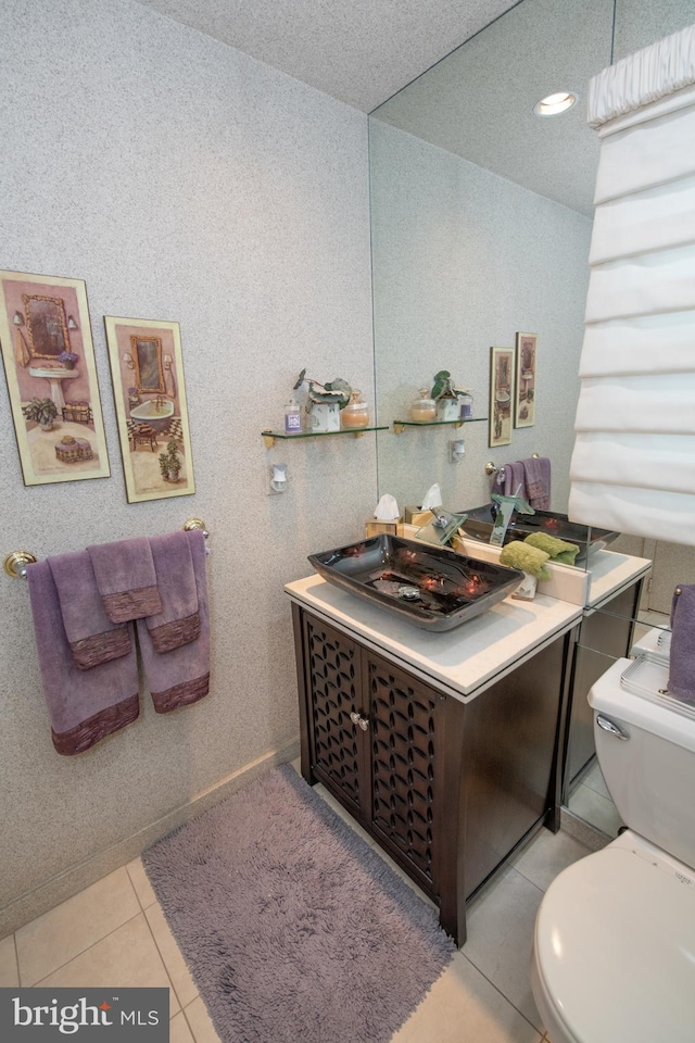 bathroom featuring tile patterned flooring, toilet, and vanity