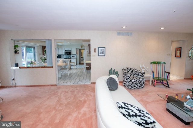 carpeted living area featuring recessed lighting and baseboards