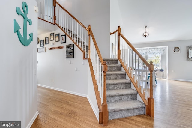 staircase with baseboards and wood finished floors