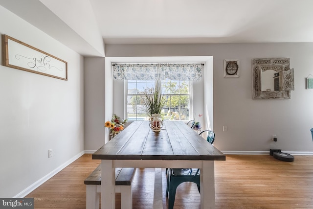 dining area featuring baseboards and light wood-style flooring