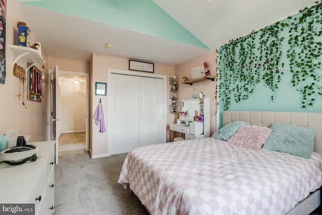 carpeted bedroom with a closet and lofted ceiling