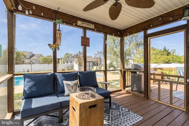 sunroom / solarium featuring ceiling fan, a healthy amount of sunlight, and an outdoor hangout area