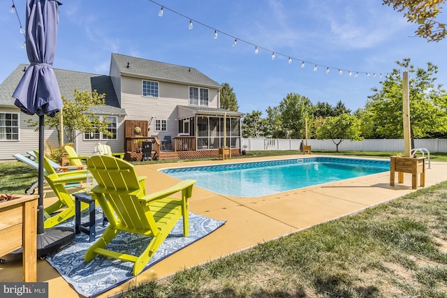 view of swimming pool featuring a wooden deck, a sunroom, a fenced backyard, a fenced in pool, and a patio