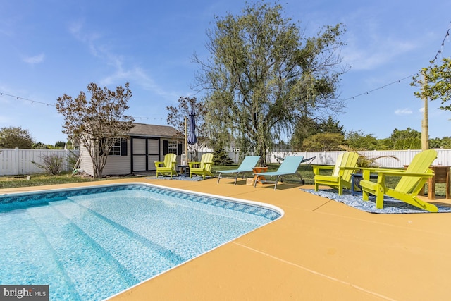 view of swimming pool with an outdoor structure, a fenced backyard, and a fenced in pool