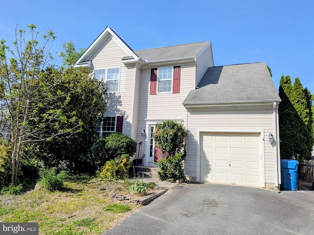 view of front of house with a garage, a shingled roof, and driveway