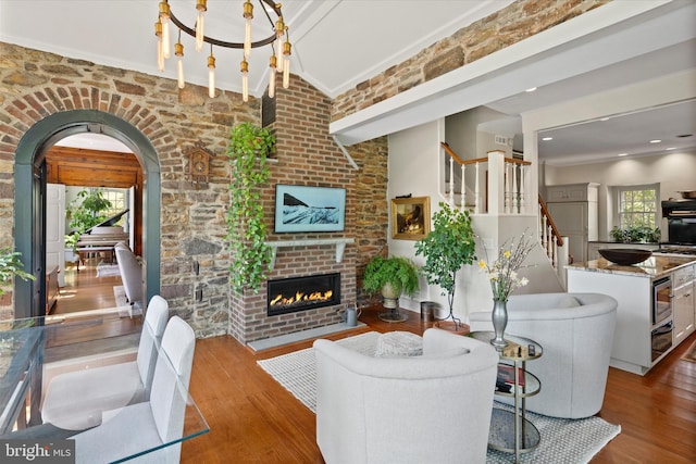 805 Evans Rd, Gwynedd Valley, PA 19437 - living area with wood finished floors, arched walkways, a brick fireplace, stairs, and ornamental molding
