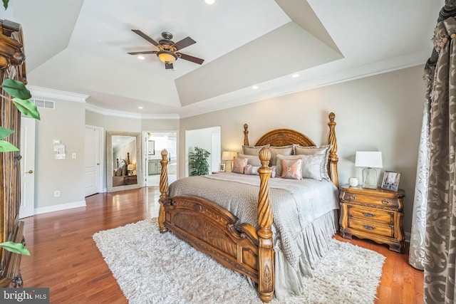 bedroom with visible vents, wood finished floors, and a raised ceiling