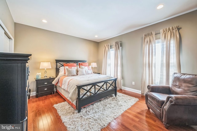 bedroom with wood-type flooring, recessed lighting, and baseboards