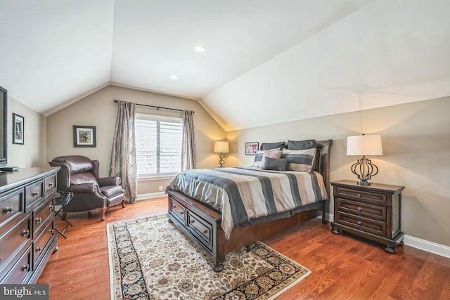 bedroom with wood finished floors, baseboards, and lofted ceiling