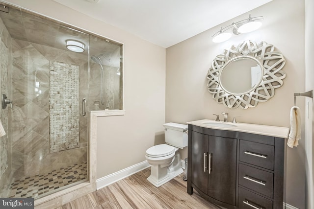 full bath with a stall shower, wood finished floors, vanity, baseboards, and toilet