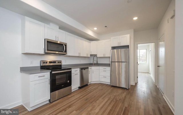 727 N 39th St, Philadelphia, PA 19104 - kitchen with white cabinets, appliances with stainless steel finishes, recessed lighting, baseboards, and wood finished floors