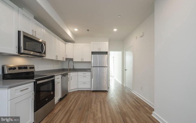 727 N 39th St, Philadelphia, PA 19104 - kitchen featuring appliances with stainless steel finishes, wood finished floors, baseboards, recessed lighting, and white cabinetry