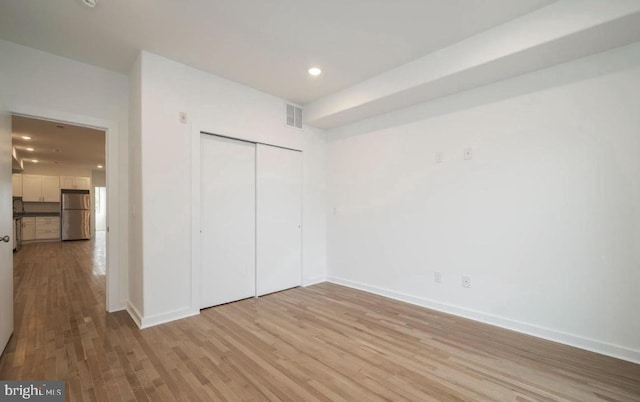 727 N 39th St, Philadelphia, PA 19104 - unfurnished bedroom with visible vents, freestanding refrigerator, light wood finished floors, and baseboards