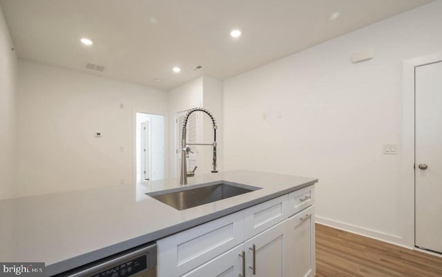 727 N 39th St, Philadelphia, PA 19104 - kitchen with visible vents, a sink, light countertops, white cabinets, and light wood-style flooring