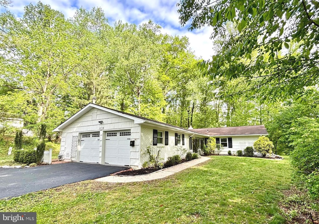 ranch-style house with driveway, a front lawn, and brick siding