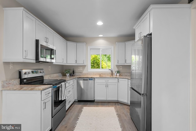1725 Stratton Rd, Crofton, MD 21114 - kitchen featuring stainless steel appliances, recessed lighting, white cabinets, a sink, and light wood-type flooring