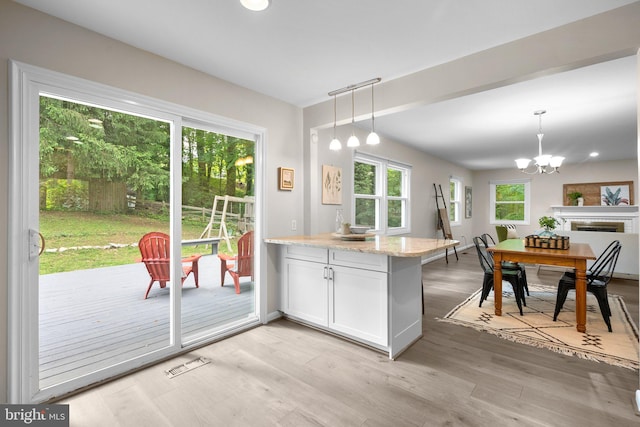1725 Stratton Rd, Crofton, MD 21114 - kitchen featuring a chandelier, light wood finished floors, decorative light fixtures, and light stone countertops
