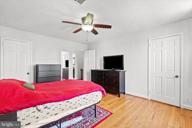 bedroom with wood-type flooring, a ceiling fan, baseboards, and visible vents