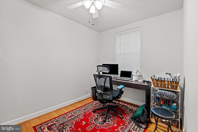 office area featuring baseboards, a ceiling fan, and wood finished floors