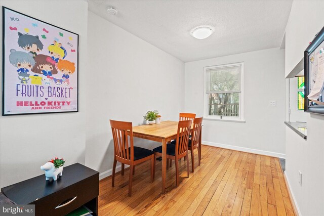 dining area featuring baseboards and light wood-style flooring