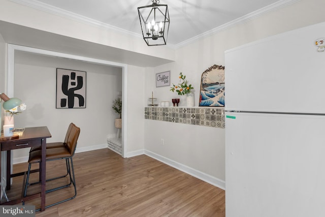 13405 Wisteria Dr, Germantown, MD 20874 - dining area featuring a chandelier, wood finished floors, ornamental molding, and baseboards