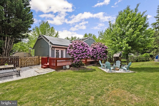 13405 Wisteria Dr, Germantown, MD 20874 - back of house with a fire pit, a wooden deck, solar panels, french doors, and a patio