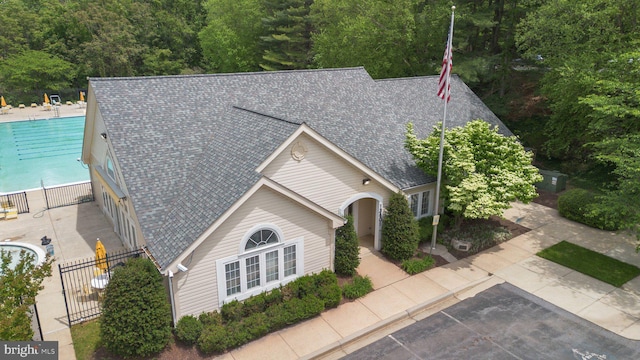 13405 Wisteria Dr, Germantown, MD 20874 - view of front facade with a shingled roof, a community pool, and fence