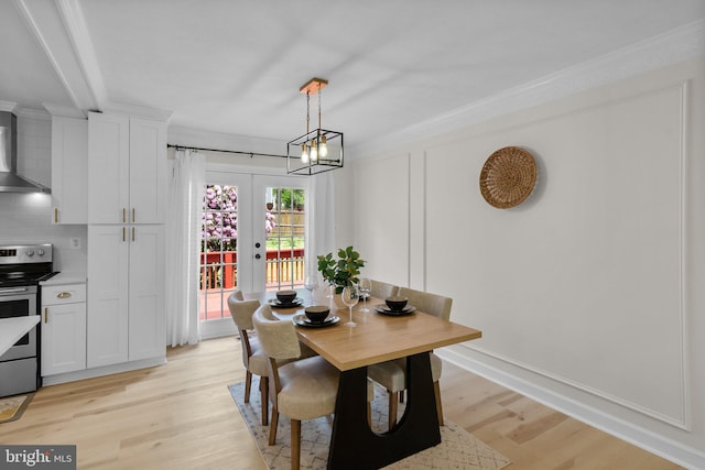 13405 Wisteria Dr, Germantown, MD 20874 - dining space featuring light wood-type flooring, ornamental molding, french doors, and a chandelier