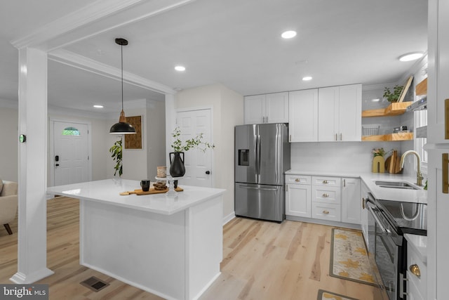 13405 Wisteria Dr, Germantown, MD 20874 - kitchen with stainless steel appliances, a sink, light wood-style floors, white cabinets, and ornamental molding