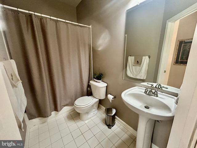 bathroom featuring a sink, tile patterned flooring, toilet, baseboards, and a shower with curtain