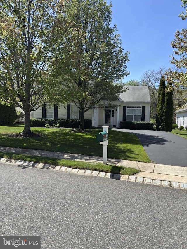 view of front facade featuring driveway and a front yard