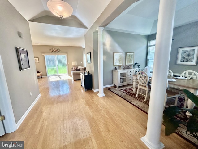 hallway with baseboards, plenty of natural light, decorative columns, and light wood-type flooring