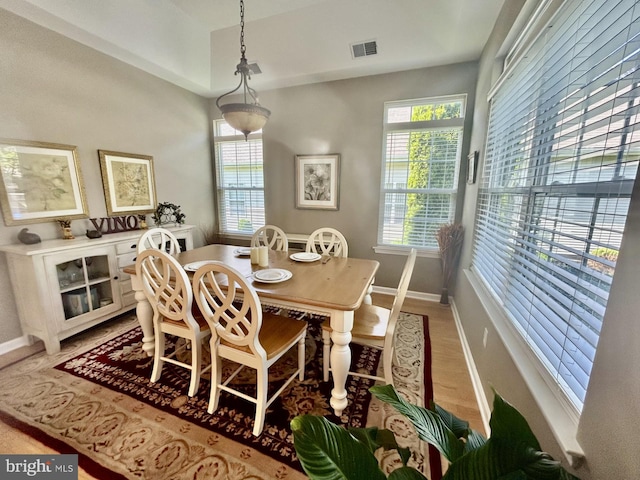 dining room with baseboards, plenty of natural light, light wood-type flooring, and visible vents