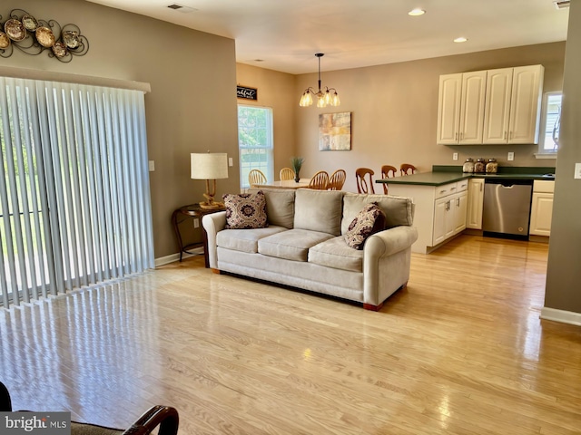 living area with recessed lighting, light wood-style flooring, a chandelier, and a wealth of natural light