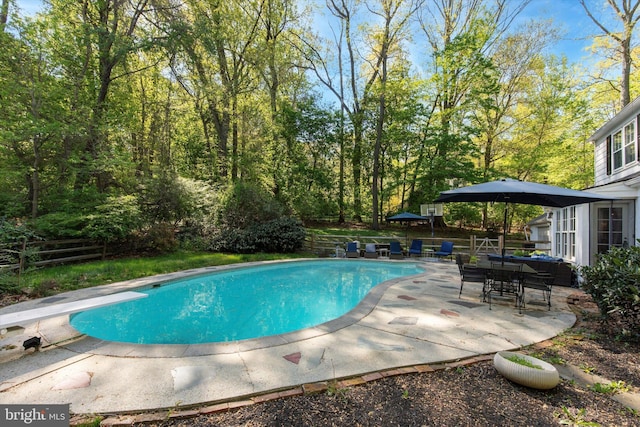 outdoor pool with a patio and fence