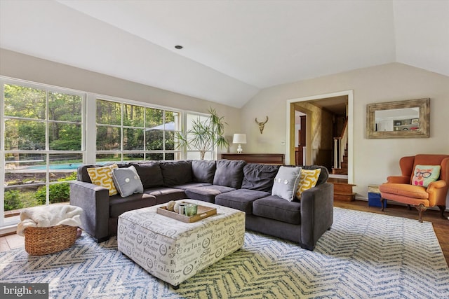 living room with stairway, wood finished floors, and lofted ceiling