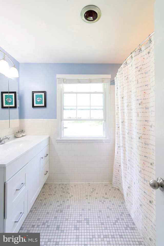 5 Gailridge Ct, Lutherville Timonium, MD 21093 - bathroom featuring vanity, tile walls, a wainscoted wall, tile patterned floors, and a shower with curtain