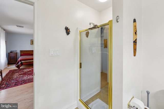 ensuite bathroom featuring baseboards, ensuite bathroom, a shower stall, and visible vents